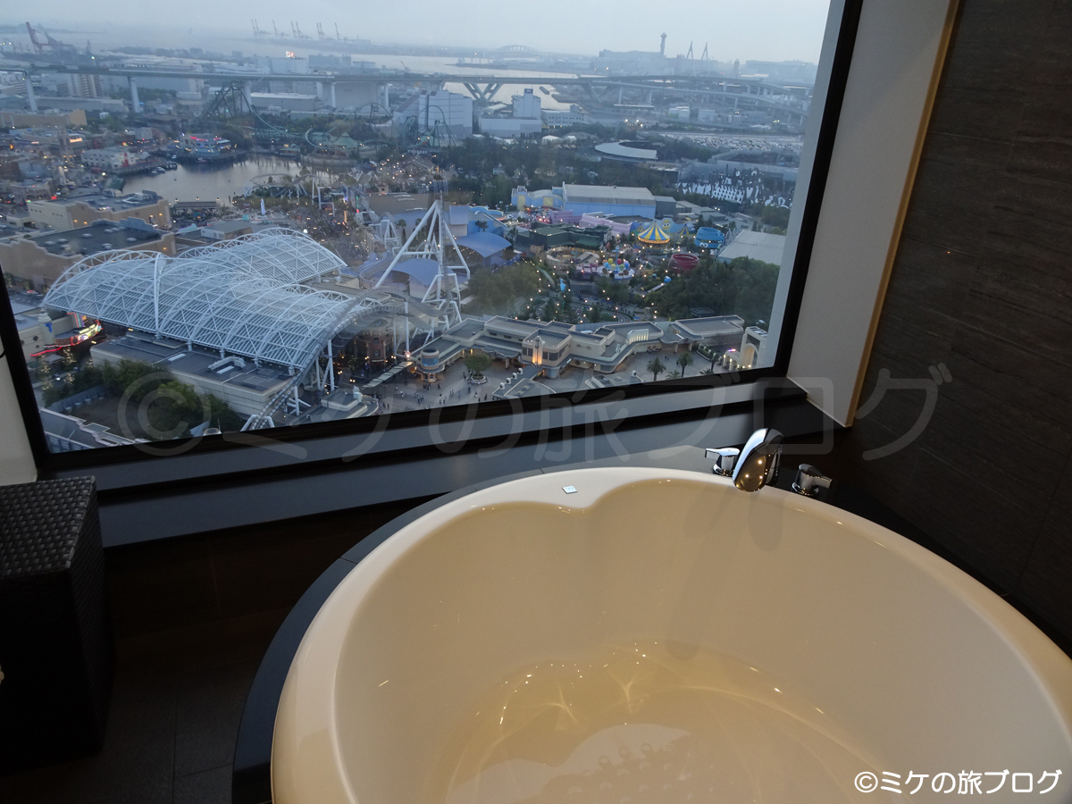 「ザ パーク フロント ホテル アット ユニバーサル・スタジオ・ジャパン」のビューバスタイプの部屋の風呂と窓の外に見えるUSJ